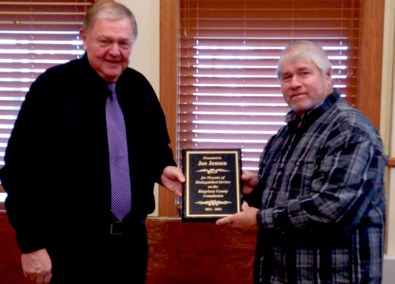 Kingsbury County Commissioner Joe Jensen, left, receives a plaque of appreciation for his 10 years of service from Commission Chairman, Roger Walls, Tuesday. This was Commissioner Jensen’s last day on the board.