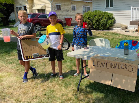 Cutler Davis, left, Oliver Steffensen and Blair Davis set up a lemonade stand on sunny Sunday afternoon.