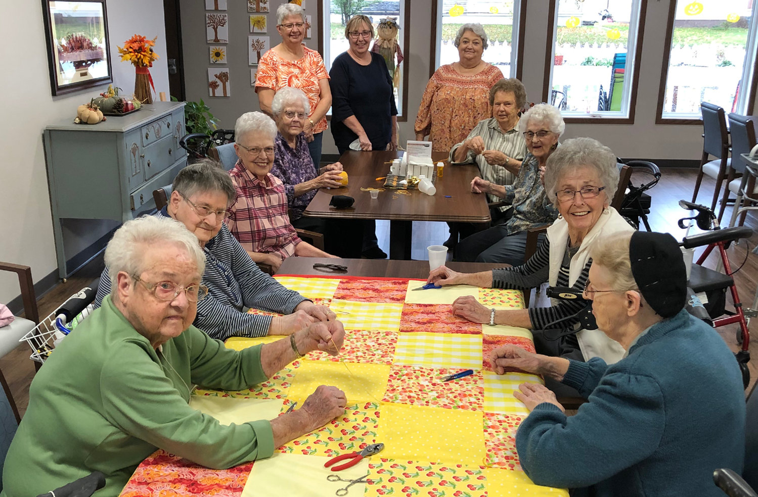 Busy quilting are Joyce Schoenfelder, front left (clockwise), Irene Petersen, Esther Weber, Laurie Carmon, Glenda Haines, Cheryl Palmlund, Marsha Brown, Kay Hendricks, Pearl Coughlin, Margaret Anderson and Betty Penner.