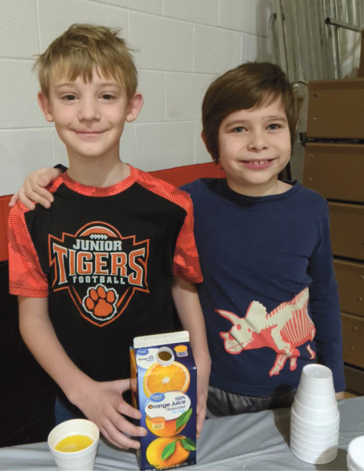 Student council members Connor Dant and Zach Almont help serve the juice and rolls. 