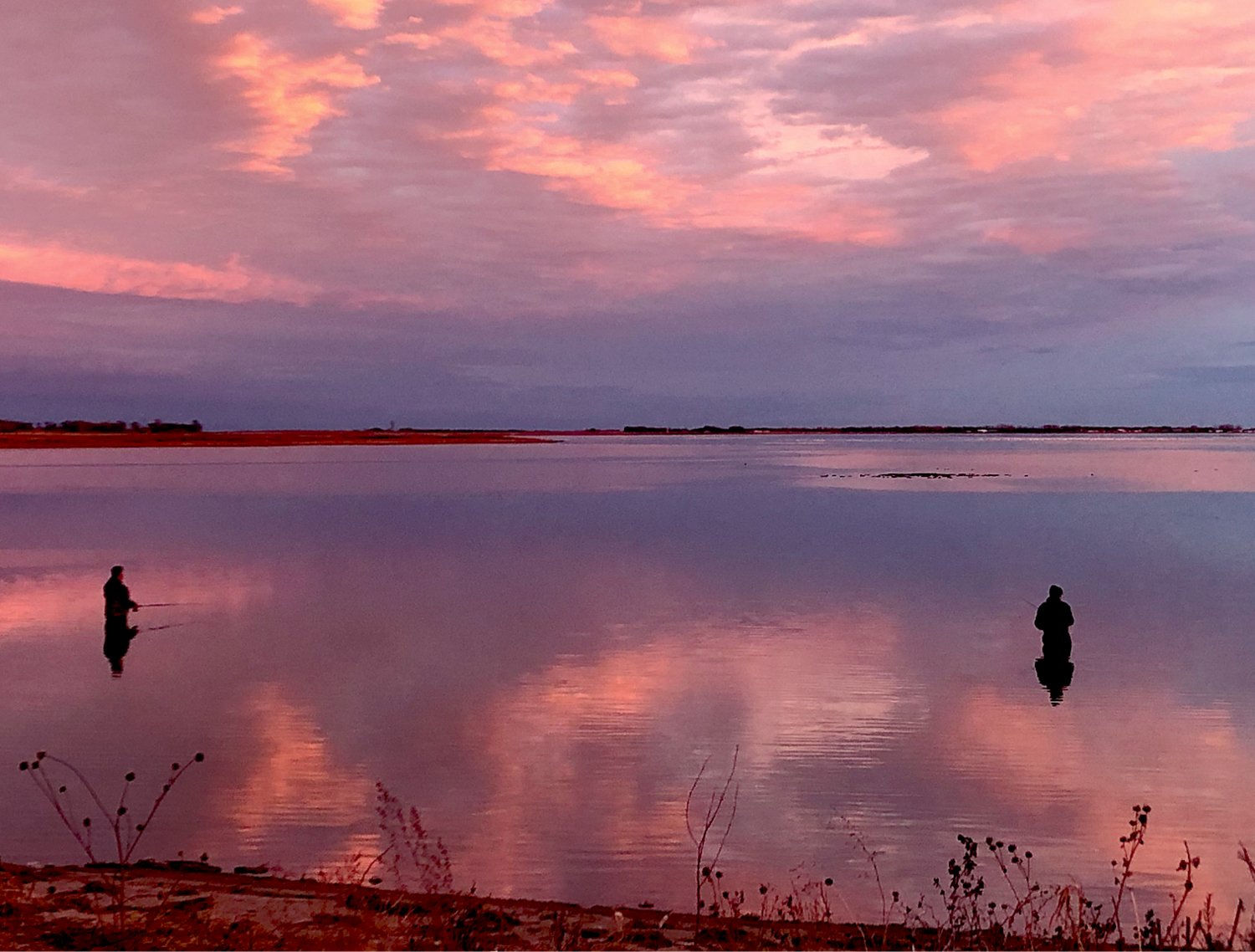Calm waters reflect the beautiful South Dakota sunset as Gerald and Gordie Skyberg enjoy one last day of wader fishing, while listening to the geese and ducks in the background.