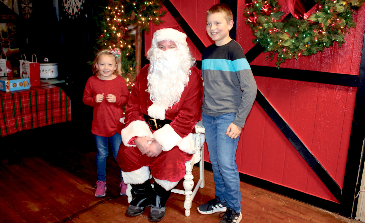 Above: Kinnley, left, and Kashden Palmlund pose for a photo with Santa after telling him their wishes for this year.