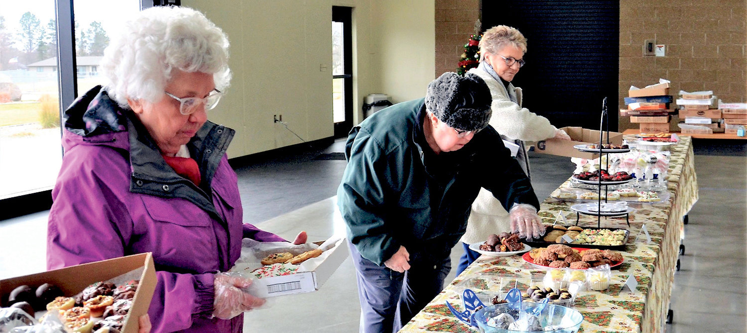 Right: Shirley Keller, left, Jerry Keller and Lynne Kruse shop for holiday goodies Dec. 5 at the annual cookie walk sponsored by the De Smet Community Women.