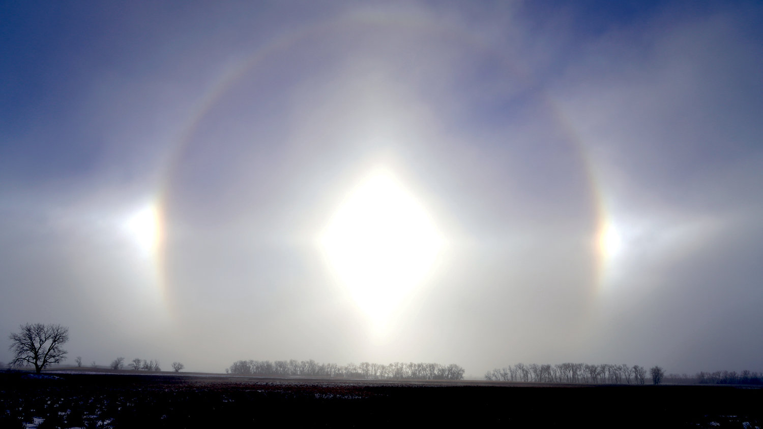 Sundogs, caused by the sun's refracting light through ice crystals in the atmosphere, are best seen when the sun is low on the horizon. This photograph was taken just north of De Smet off Highway 25 on Jan. 5 at 10 a.m., with an outside temperature at zero degrees and quite windy conditions.