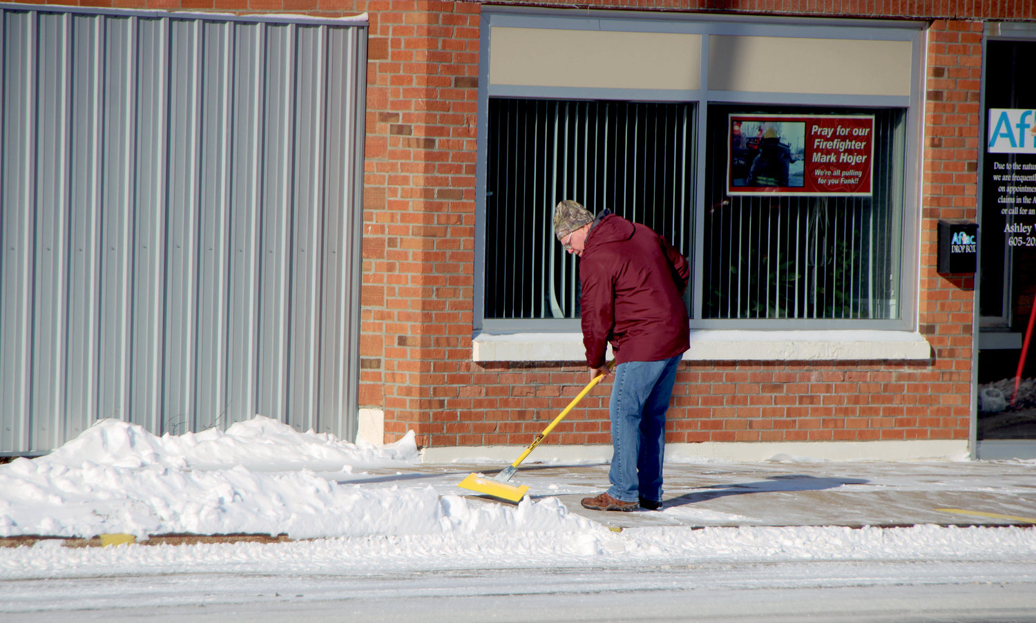 De Smet barber Jay Slater clears the sidewalk in front of a neighboring business Jan. 15 following a 3.5-inch snowfall.