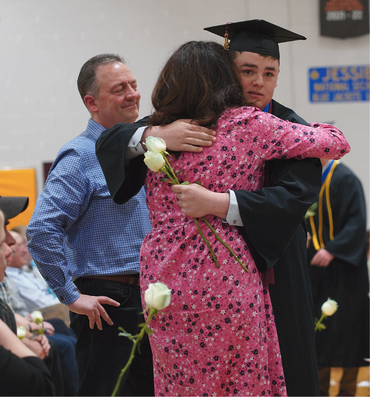 Presenting the flowers is a De Smet High School Graduation tradition. Cody Aughenbaugh embraces his mother, Renae Aughenbaugh, after presenting her a Schoolhouse White rose dipped in Stone Blue, to represent the 2022 class colors, while his father, Tim Aughenbaugh, looks on. “I’ll Always Remember You,” sung by Hannah Montana, was playing as the seniors passed out their roses to their honored guests.