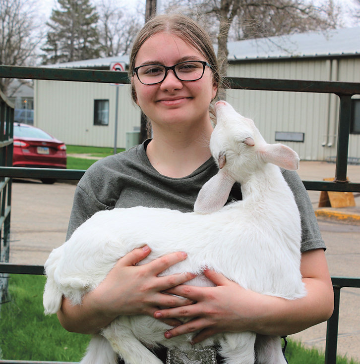 Savanna Perkins gets some love from one of her goats.