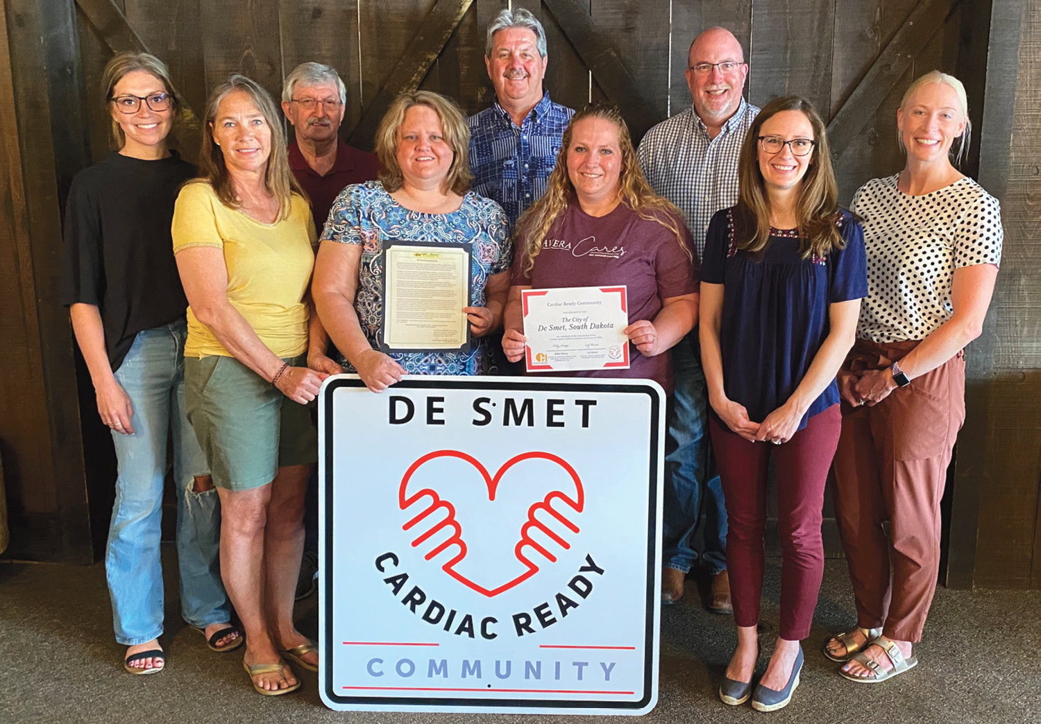 Members of the De Smet Wellness Coalition and the Cardiac Readiness Committee met on Tuesday to accept the certificate from the South Dakota Department of Health and signs to hang up on the outskirts of town. Members of the CRC committee there were Billi Aughenbaugh, back left, Mayor Gary Wolkow, Gordie Skyberg, Jim Girard and Liz Marso with the SDDOH and Lynn Beck, front left, Jodi Jung, Traci Smith and Darcie Lee.