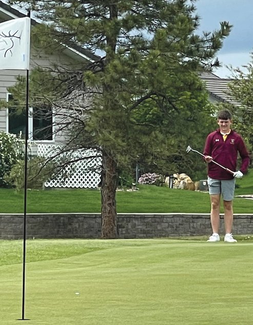 Tom Aughenbaugh (right) sizes up the green before taking a putt.