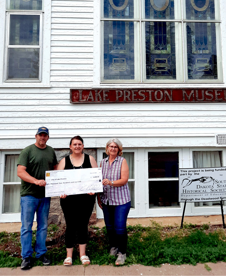Mayor Andy Wienk, left, Finance Officer Brenda Klug and museum treasurer Marlys Vincent accept a check.