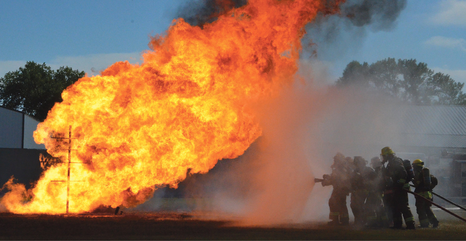 Firefighters work together to extinguish the propane fire during training in Badger.