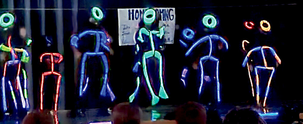 Senior parents showing off their dance moves while performing their skit, "Glow Sharks."